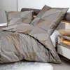 A close-up view of a neatly made bed with geometric patterned bedding. Produktbild-Vorschau