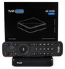 A TVIP S-Box media player and its remote control are displayed in front of the product's packaging. Podgląd zdjęcia produktu