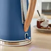 Close-up of a blue kettle with a wooden handle, on a wooden table, with a jar of jam in the background. Produktbild-Vorschau