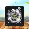A black square fan with a metal grill is placed on a wooden surface, with a blurred background of a sky and trees. Náhled obrázku produktu