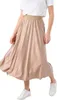A person wearing a beige pleated skirt and white sneakers. Produktbild-Vorschau