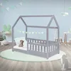 A child's bedroom with a grey house-shaped bed, a teddy bear on the mattress, and decorative bunting. Produktbild-Vorschau