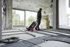 A person is pulling a tool case on wheels through a construction site with many pipes on the floor. Produktbild-Vorschau