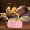 A baby sleeping next to a teddy bear, with a pink toy gramophone playing music. Produktbild-Vorschau