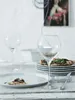 A table setting with plates, glasses, and food, suggesting a meal. Produktbild-Vorschau