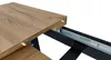 A close-up view of a table extension mechanism, showing the wooden tabletop and metal sliding rails. Náhled obrázku produktu