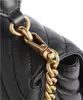 A close-up shot of the hardware and stitching on a black quilted handbag. Voir les images du produit