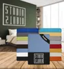 A stack of folded bed sheets in various colors, with a bedroom scene in the background. Produktbild-Vorschau