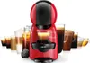 A red and black Nescafe Dolce Gusto coffee machine is shown in front of a display of various coffee drinks. Anteprima dell’immagine prodotto