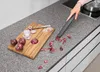 A person is using a small vacuum cleaner to clean up onion peels from a kitchen countertop. Podgląd zdjęcia produktu