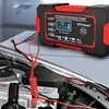 A car battery charger is connected to a car battery inside an engine bay. Podgląd zdjęcia produktu