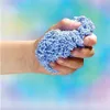 A hand squeezing a ball of light blue Playfoam. Produktbild-Vorschau