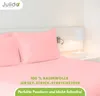 A pink bed with pillows and a bedside lamp. Produktbild-Vorschau