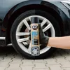 A gloved hand holds a can of tire care spray in front of a car tire and wheel. Produktbild-Vorschau