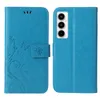 A blue flip phone case with a floral and butterfly embossed design is shown from the front and back. Produktbild-Vorschau