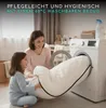A mother and daughter are putting a mattress into a washing machine. Produktbild-Vorschau
