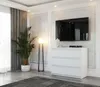 A modern living room with a TV mounted above a white dresser, a floor lamp, and a large potted plant. Produktbild-Vorschau