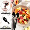 A close-up of black plastic spoons next to a bowl of fruit salad, with text overlays highlighting product features. Produktbild-Vorschau