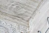 A close-up view of the corner of a wooden chest with intricate carvings. Voir les images du produit