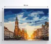 A painting of a European marketplace with a prominent clock tower at sunset. Podgląd zdjęcia produktu