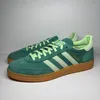 A pair of green Adidas Handball Spezial sneakers are shown from a side-diagonal angle against a white background. Produktbild-Vorschau