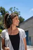 A woman wearing headphones outdoors on a sunny day. Náhled obrázku produktu