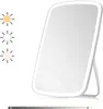 A white LED makeup mirror with a stand, shown against a white background. Three sun icons indicating different light settings are visible to the left. Produktbild-Vorschau