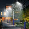 A modern house with a pathway leading to the entrance, illuminated by several solar-powered streetlights at dusk. Voir les images du produit