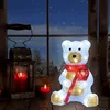 A festive Christmas scene with a lit teddy bear decoration and candles in a window setting. Produktbild-Vorschau