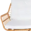 A close-up view of a rattan chair with white cushions. Produktbild-Vorschau