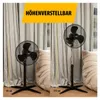 Two stand fans are shown side-by-side, one at a lower height and one at a higher height, to demonstrate adjustability. The background features light-colored curtains and a plush armchair. Voir les images du produit