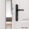 A close-up view of a black door handle and lock mechanism on a white door. Podgląd zdjęcia produktu