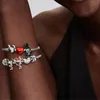 A close-up shot of a person's arm wearing two Pandora Disney-themed charm bracelets. Podgląd zdjęcia produktu