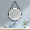 A bathroom vanity with a light blue sink and a round LED mirror hanging above it. Náhled obrázku produktu