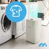 A white dehumidifier is shown next to a washing machine in a laundry room, with a graphic overlay indicating its function. Voir les images du produit