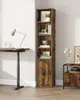 A tall, narrow bookshelf with a door at the bottom, placed next to a standing desk. Náhled obrázku produktu