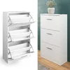 A white shoe cabinet with three flip-down drawers is shown on the left, and a similar cabinet with closed drawers is shown on the right, decorated with a potted plant. Produktbild-Vorschau