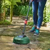 A person is using a pressure washer with a patio cleaner attachment on a stone patio in a garden. Produktbild-Vorschau
