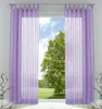 A pair of sheer purple curtains hangs in front of a window, revealing a green tree and blue sky outside. Produktbild-Vorschau