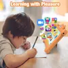 A young boy is drawing on a piece of paper while a tablet with various app icons is propped up in front of him. Produktbild-Vorschau