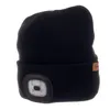 A black beanie with a built-in LED light and a small brown leather tag with a logo. Produktbild-Vorschau
