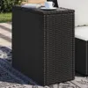 An outdoor setting with a wicker side table on a rug, next to a sofa. Produktbild-Vorschau