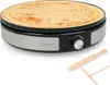A crêpe maker with a crêpe on it and two wooden accessories for making crêpes. Anteprima dell’immagine prodotto