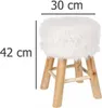 A white fluffy stool with wooden legs is shown with dimensions indicated. Podgląd zdjęcia produktu