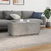 A modern living room scene with a gray sectional sofa, a concrete-effect coffee table, and a potted plant. Produktbild-Vorschau