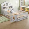 A child's bed with protective railings and a headboard shelf, set in a room with a desk and chairs. Anteprima dell’immagine prodotto