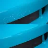 A close-up comparison of a blue surface before and after cleaning, showing a black mesh grille in the background. Produktbild-Vorschau