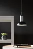 A modern pendant light hangs above a table with a notebook and pen. Produktbild-Vorschau