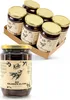 A close-up view of a single jar of Kalamata olives in the foreground, with a cardboard box containing six jars of olives in the background. Produktbild-Vorschau