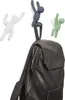Three decorative hooks shaped like climbing figures, with a backpack hanging from one. Náhled obrázku produktu